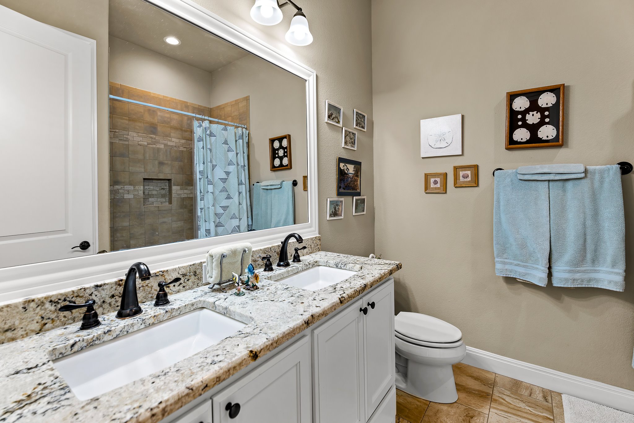 204 Venture Boulevard South Point Venture, TX 78645 - Photo 22 of 40 a bathroom with a granite countertop sink mirror vanity and toilet