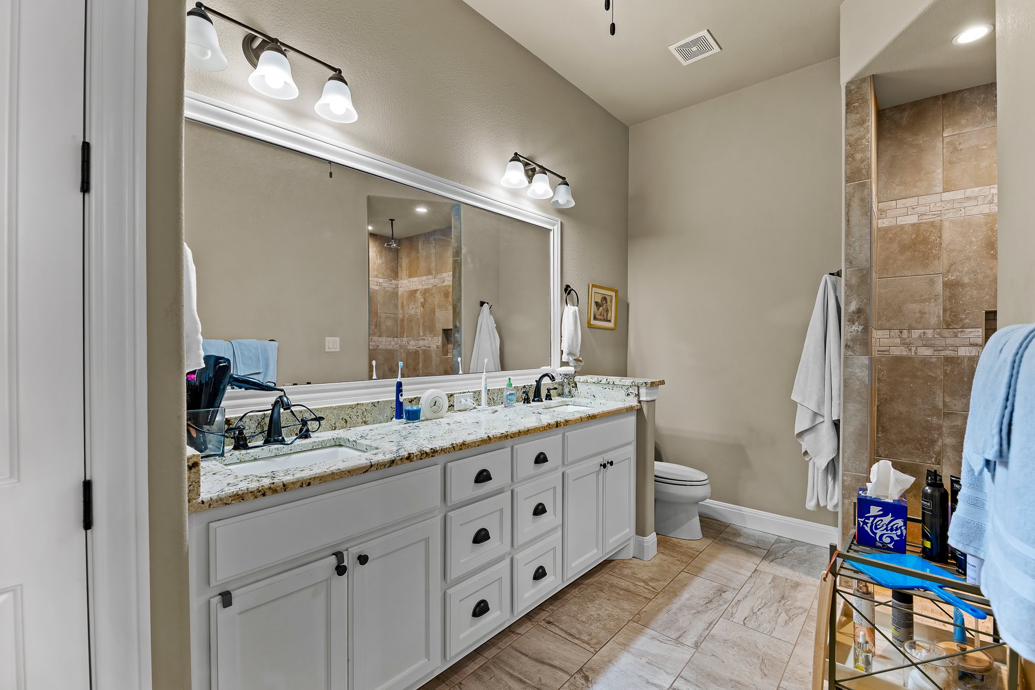 204 Venture Boulevard South Point Venture, TX 78645 - Photo 26 of 40 a bathroom with a granite countertop sink a mirror and a shower