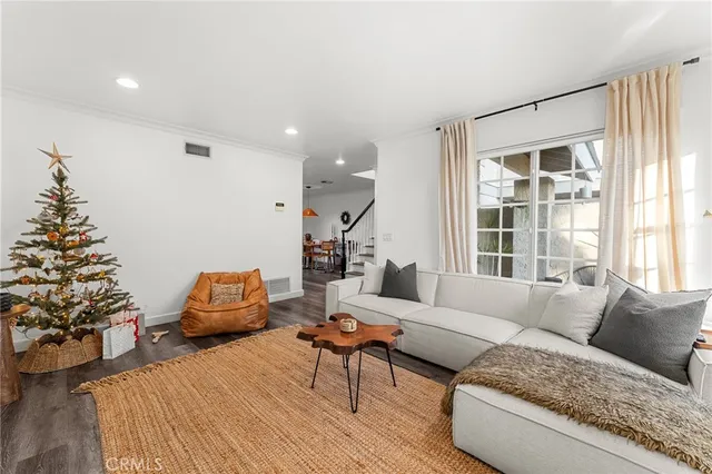 a living room with wooden floor furniture and a potted plant