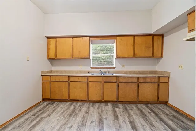 a view of a kitchen with wooden floor and a window