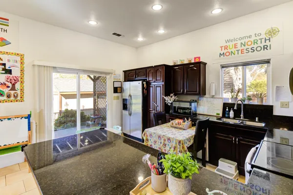 a kitchen with stainless steel appliances granite countertop a refrigerator and a sink