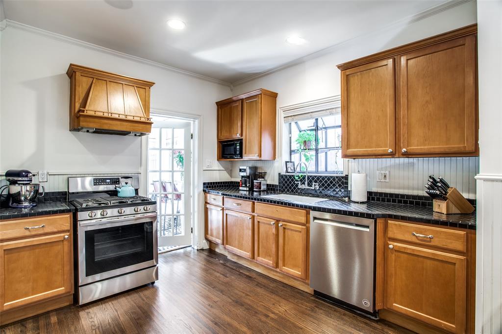 5506 Ridgedale Avenue Dallas, TX 75206 - Photo 8 of 16 a kitchen with stainless steel appliances granite countertop wooden cabinets stove top oven and sink