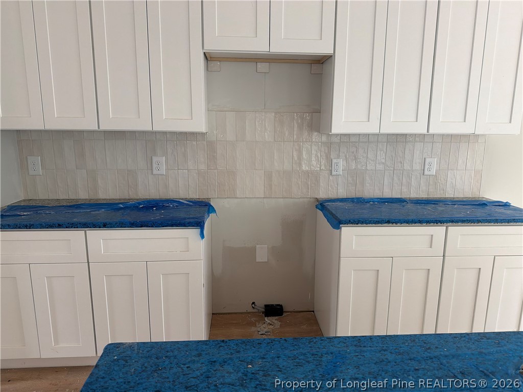 421 Needmore Road Cameron, NC 28326 - Photo 5 of 12 a kitchen with granite countertop white cabinets and a wooden floor