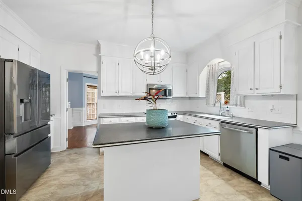 a kitchen with granite countertop white cabinets and a sink