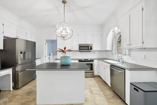 a kitchen with stainless steel appliances granite countertop a sink a window and a refrigerator