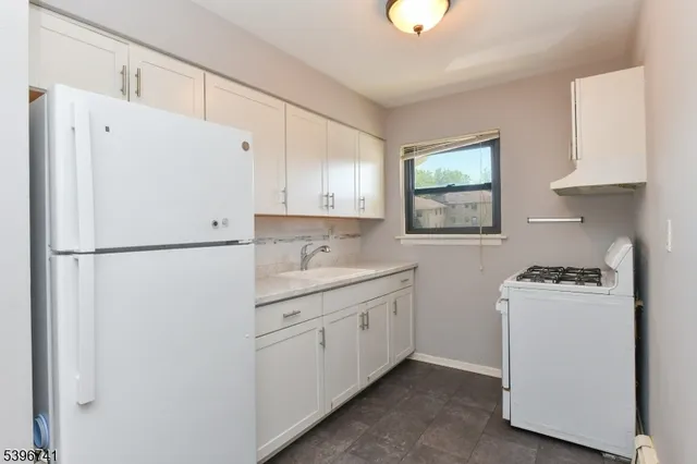 a kitchen with white cabinets and white appliances