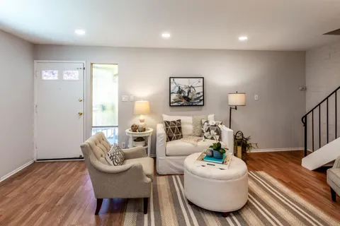a living room with furniture and a wooden floor