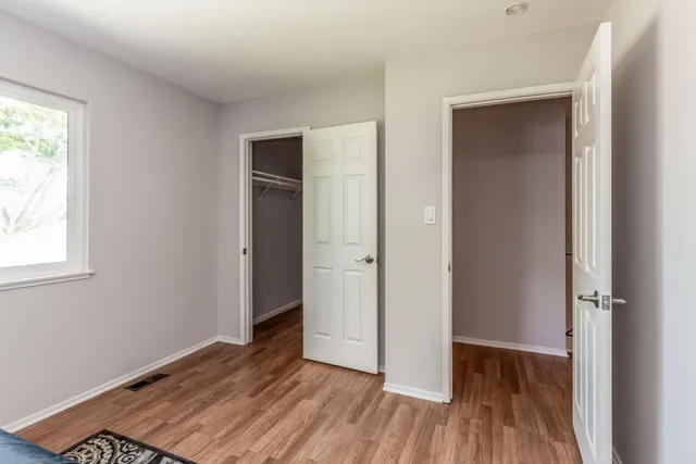 an empty room with wooden floor and a window