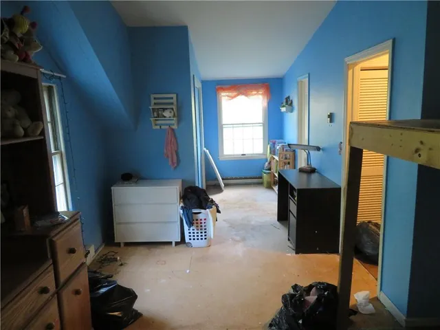 a living room with furniture a flat screen tv and a window