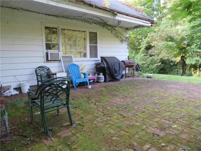 a view of backyard with seating space and wooden fence