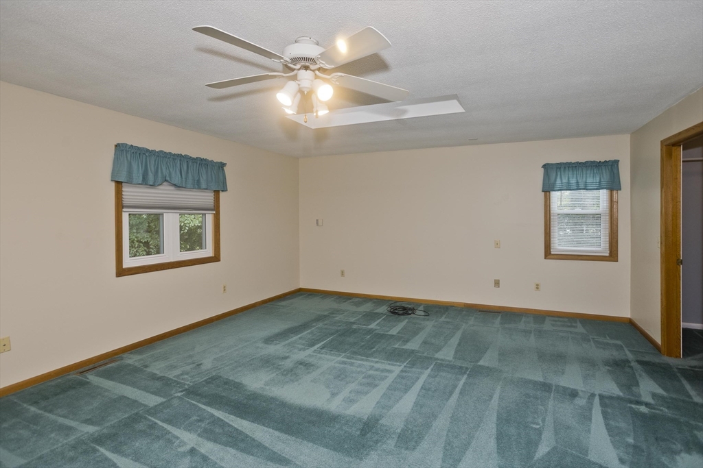 27 Bunker Circle East Longmeadow, MA 01028 - Photo 14 of 36 a view of an empty room with window and chandelier fan