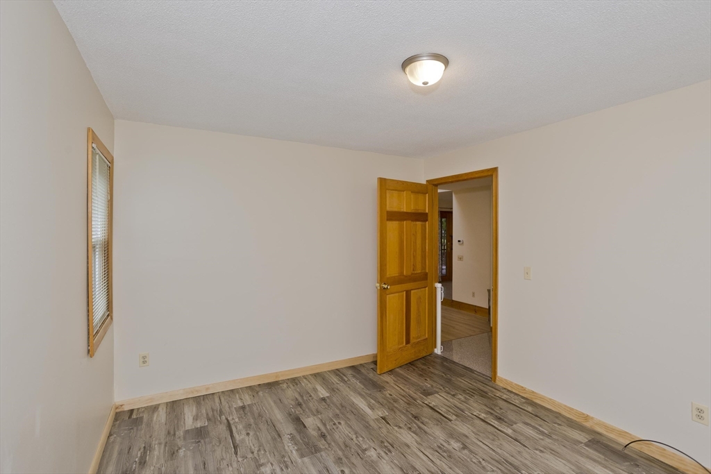 27 Bunker Circle East Longmeadow, MA 01028 - Photo 8 of 36 a view of an empty room with wooden floor and a window