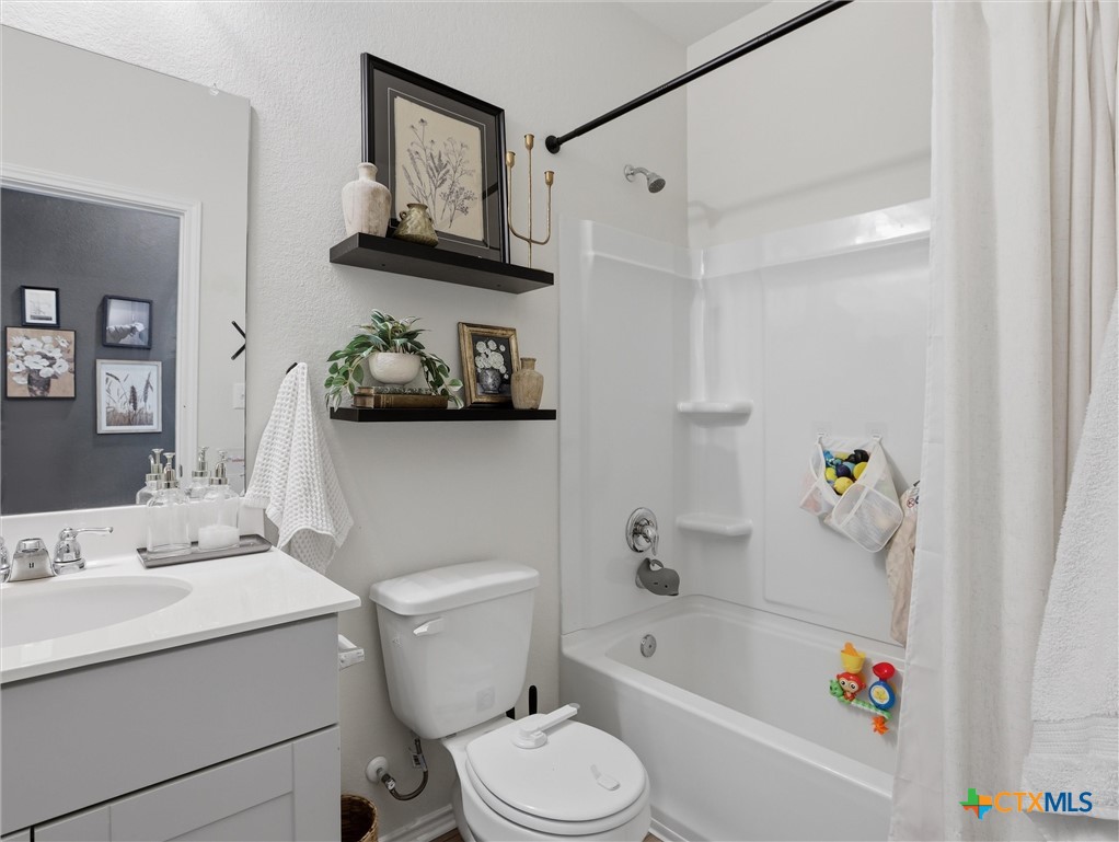 198 Orange Road Buda, TX 78610 - Photo 14 of 28 a bathroom with a sink a toilet and a bathtub