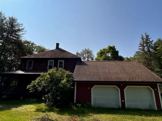 a view of a house with a wooden deck and a yard