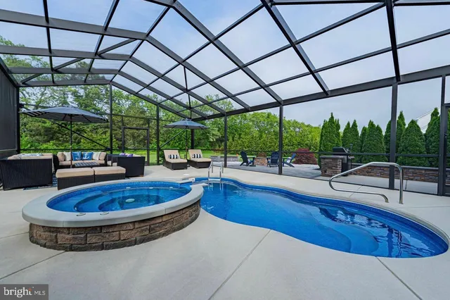 a view of a swimming pool with a couches chairs and city view