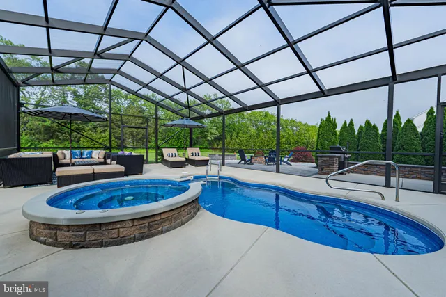 a view of a patio with swimming pool table chairs and a yard