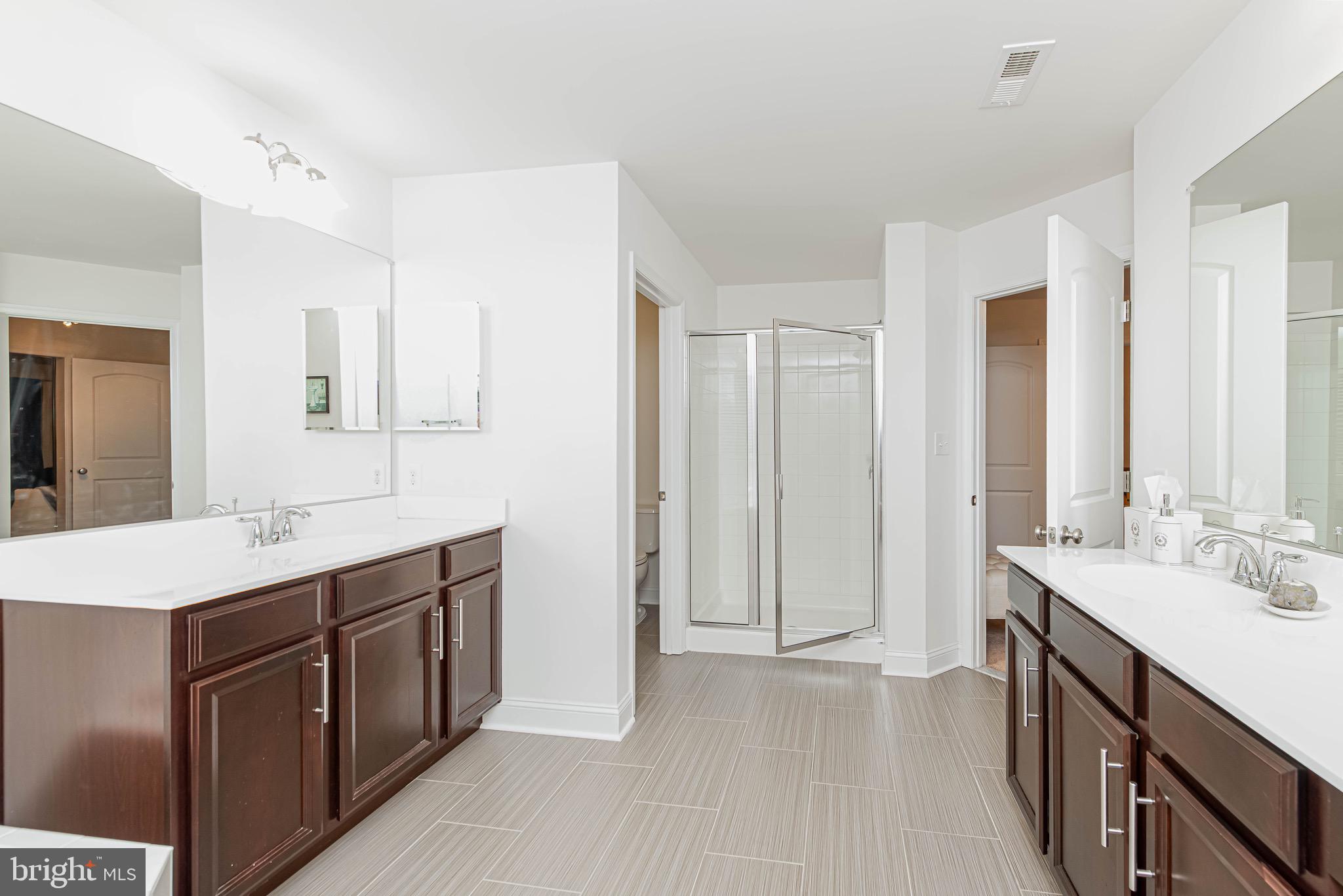 36932 Grove Estate Road Lewes, DE 19958 - Photo 72 of 105 a spacious bathroom with a double vanity sink a mirror and a shower