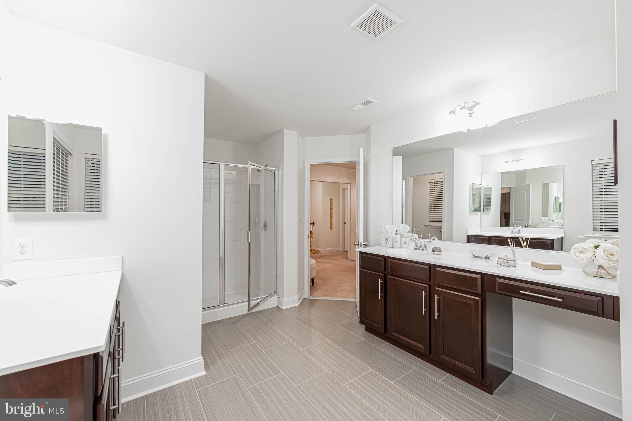 36932 Grove Estate Road Lewes, DE 19958 - Photo 73 of 105 a large bathroom with a double vanity sink and a mirror