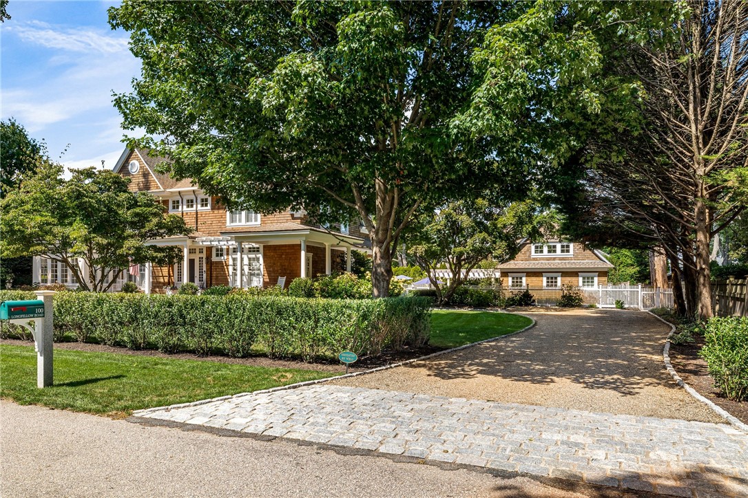 Driveway entry showing residence to the left, and pool house ahead beyond parking area