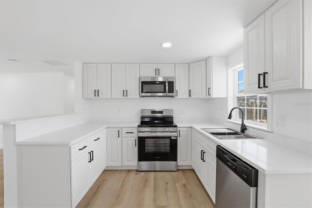 7114 Fair Lane Hudson, FL 34667 - Photo 20 of 59 a kitchen with granite countertop a stove sink and cabinets