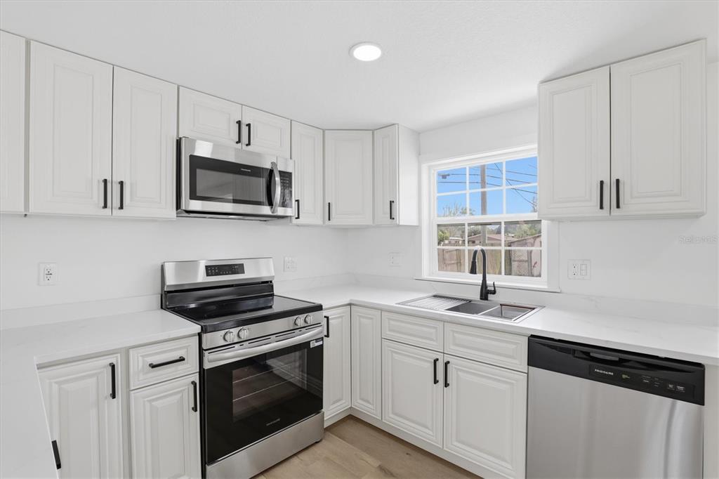 7114 Fair Lane Hudson, FL 34667 - Photo 21 of 59 a kitchen with cabinets appliances a sink and a counter top space