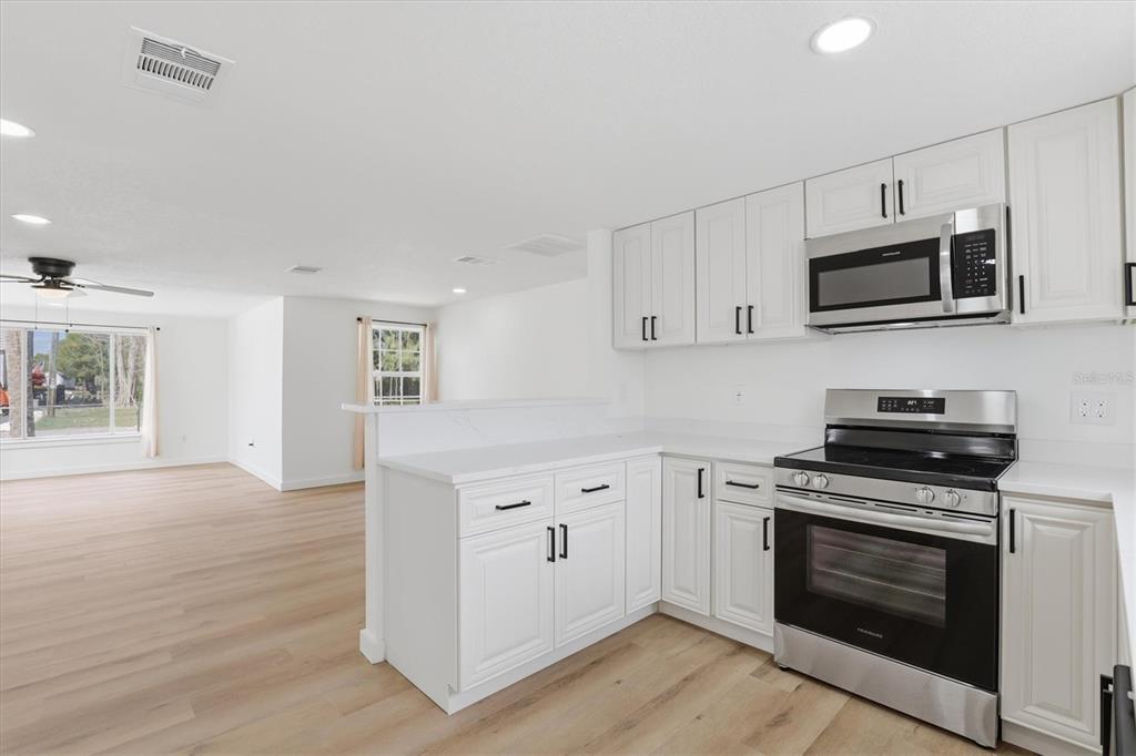 7114 Fair Lane Hudson, FL 34667 - Photo 22 of 59 a kitchen with stainless steel appliances a stove microwave and sink