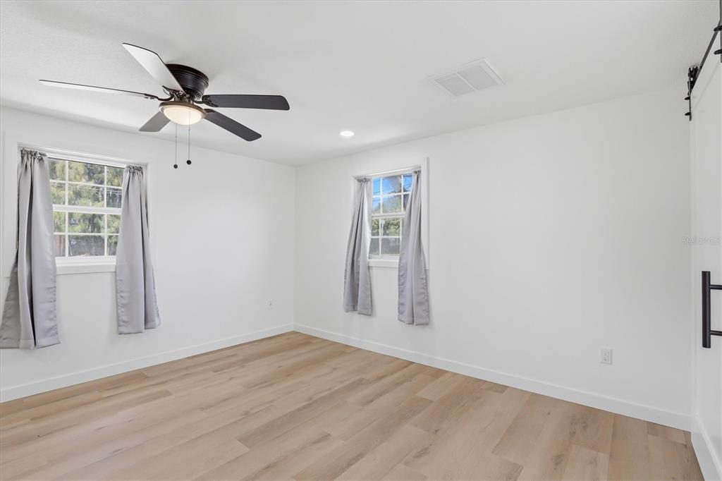 7114 Fair Lane Hudson, FL 34667 - Photo 28 of 59 a view of empty room with wooden floor and fan