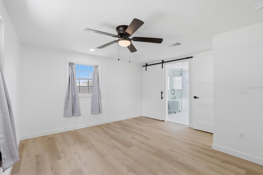 7114 Fair Lane Hudson, FL 34667 - Photo 30 of 59 a view of empty room with wooden floor and ceiling fan