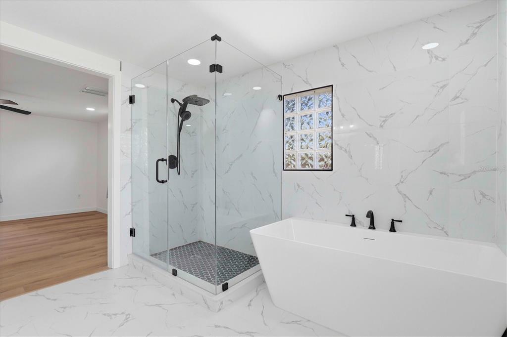 7114 Fair Lane Hudson, FL 34667 - Photo 33 of 59 a bathroom with a tub and a shower