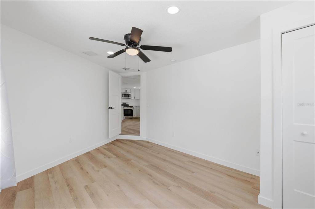 7114 Fair Lane Hudson, FL 34667 - Photo 38 of 59 a view of empty room with wooden floor and fan