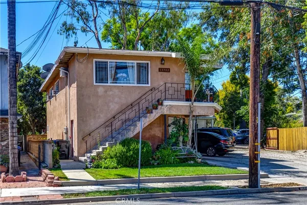 a view of a house with a yard and potted plants