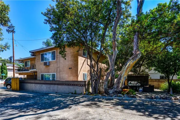 a view of a house with a tree next to a yard