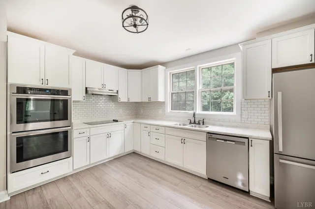 a kitchen with granite countertop white cabinets and white appliances