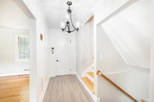 a view of a hallway with wooden floor and staircase