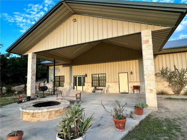 a backyard of a house with table and chairs