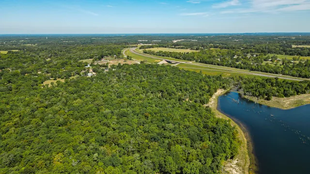 an aerial view of residential houses with outdoor space and trees