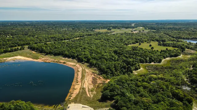an aerial view of residential houses with outdoor space and trees
