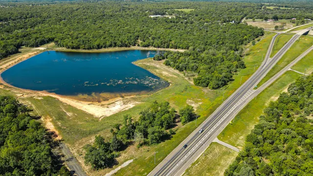 an aerial view of a residential houses with outdoor space and trees
