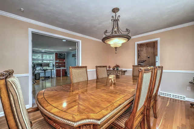 a dining room with furniture a chandelier and wooden floor