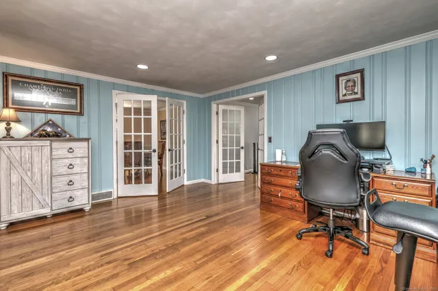 a workspace with furniture wooden floor and chandelier
