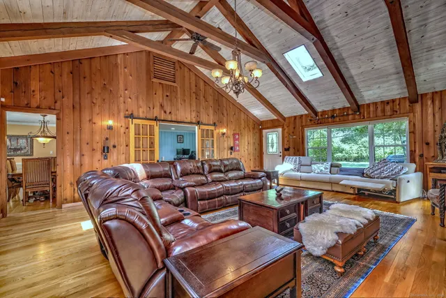 a living room with furniture a large window and wooden floor