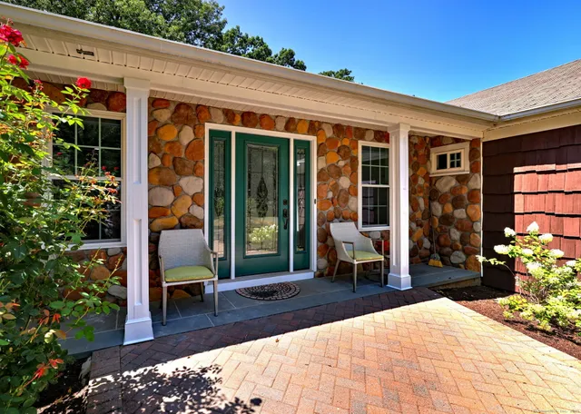 a view of a patio with chair and tables back yard of the house