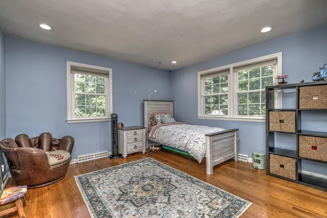 a bedroom with a bed and wooden floor