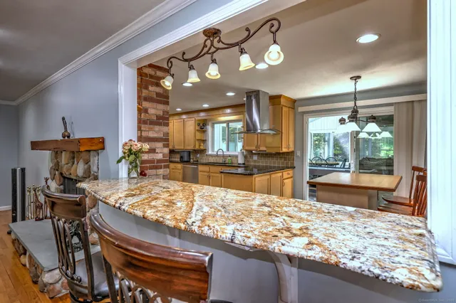 a kitchen with stainless steel appliances granite countertop a stove a sink and a wooden cabinets
