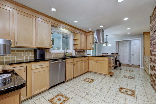 a kitchen with a sink appliances cabinets and furniture