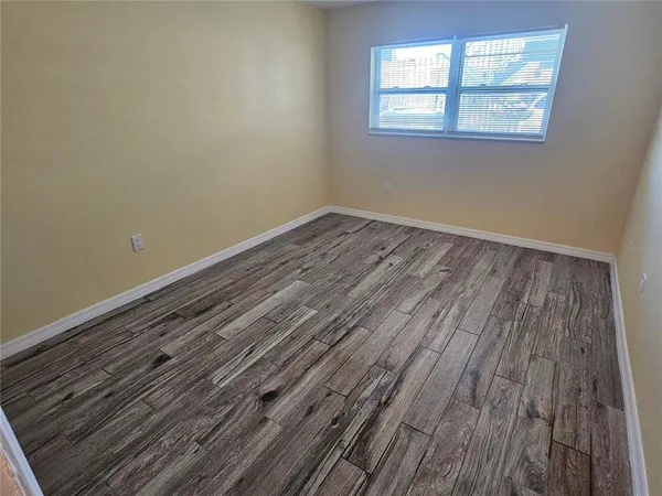 a view of a room with wooden floor and windows