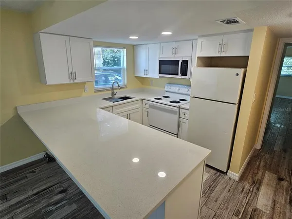 a kitchen with stainless steel appliances a refrigerator sink and microwave