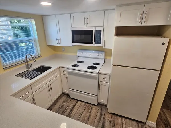 a kitchen with white cabinets and white appliances
