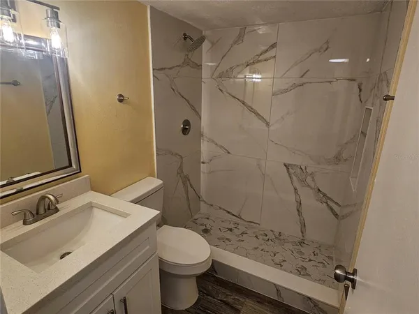 a bathroom with a sink toilet and shower