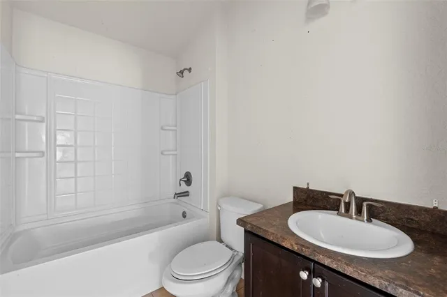 a bathroom with a granite countertop sink toilet a mirror and shower